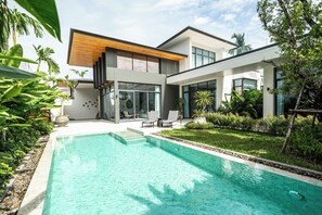 A modern house with a swimming pool, outdoor seating, and lush greenery. - Elite Chalong Villas (Chalong)