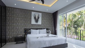 A modern bedroom with a large bed, a nightstand, a ceiling fan, and a view of the outdoors.