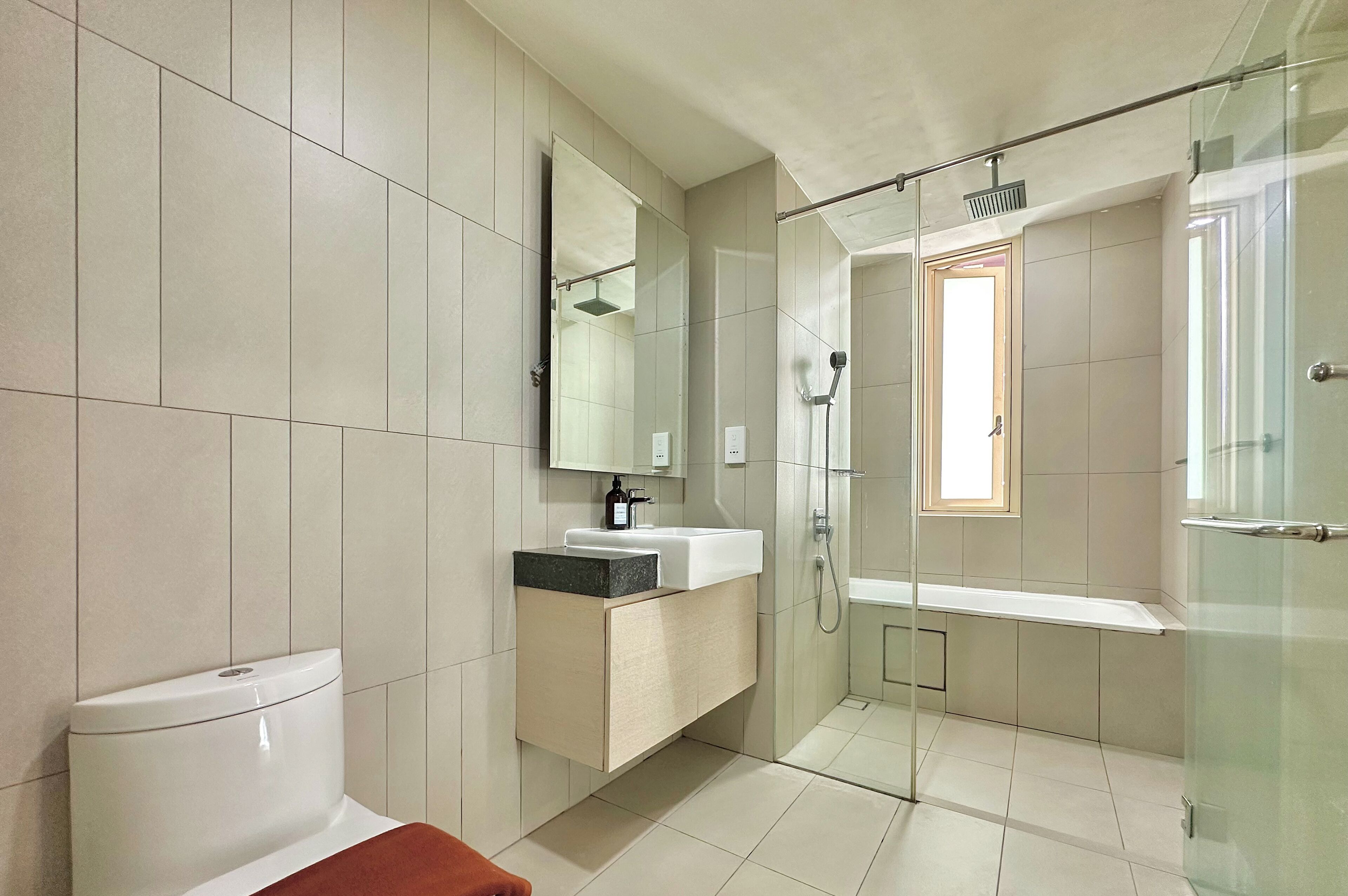 A modern bathroom with a toilet, sink, and shower area.