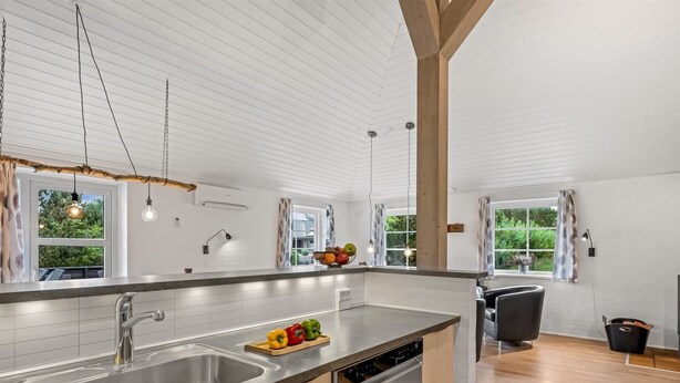 A modern kitchen with a large island, stainless steel appliances, and wooden cabinetry. - "Guthbrand" - 1.3km from the sea by Interhome (Blåvand)