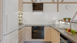 A modern kitchen with a built-in oven, a sink, and a clock on the wall. - "Guthbrand" - 1.3km from the sea by Interhome (Blåvand)