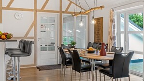 A modern dining area with a wooden table and chairs, a fruit bowl, and a menu board. - "Guthbrand" - 1.3km from the sea by Interhome (Blåvand)