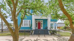 A two-story house with a red door and a blue exterior.