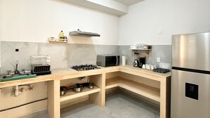 A modern kitchen with a built-in gas stove, microwave, and stainless steel refrigerator.