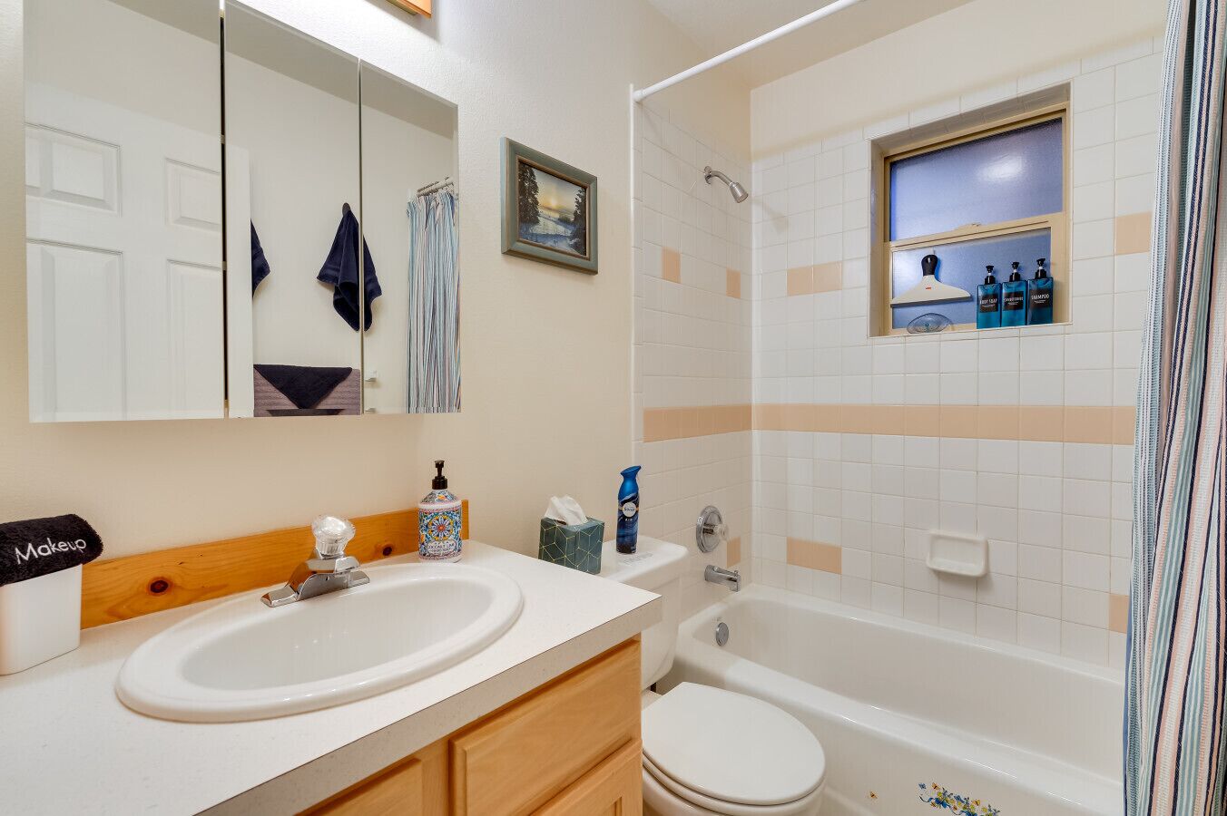 Un baño con un espejo grande, un lavabo, un inodoro y una ducha.