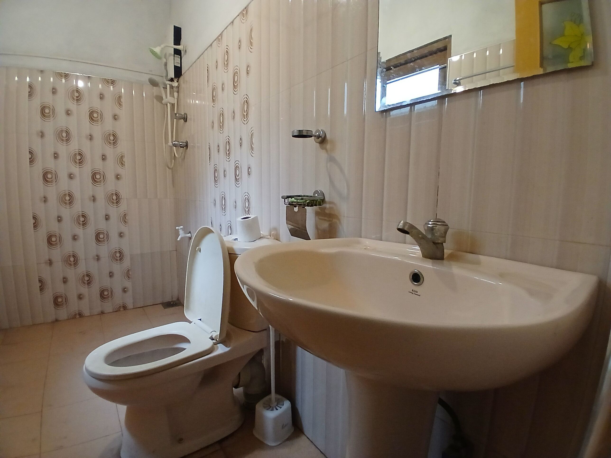 Un baño con inodoro, lavabo y ducha.
