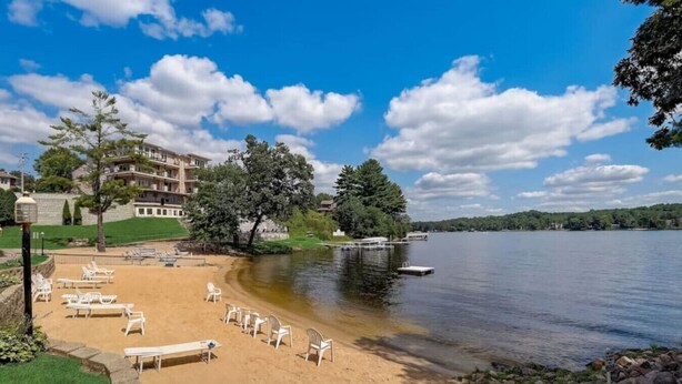 A beach with sun loungers and a building in the background.