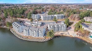 A waterfront hotel with multiple buildings, a dock, and a view of the surrounding landscape.