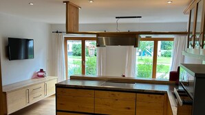 Una cocina moderna con armarios de madera, una isla central y un amplio ventanal con vistas al exterior.