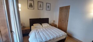 A bedroom with a bed, a nightstand, a wooden wardrobe, and three framed pictures on the wall. - Paradiski, calm and sunny vallandry (LANDRY)