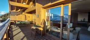 A wooden deck with outdoor furniture, a table, and chairs.