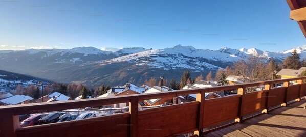 A wooden balcony overlooking a mountainous landscape with snow-covered peaks. - Paradiski, calm and sunny vallandry (LANDRY)