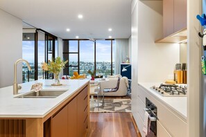 A modern kitchen with a large window, a dining area with a sofa, and a view of the city.