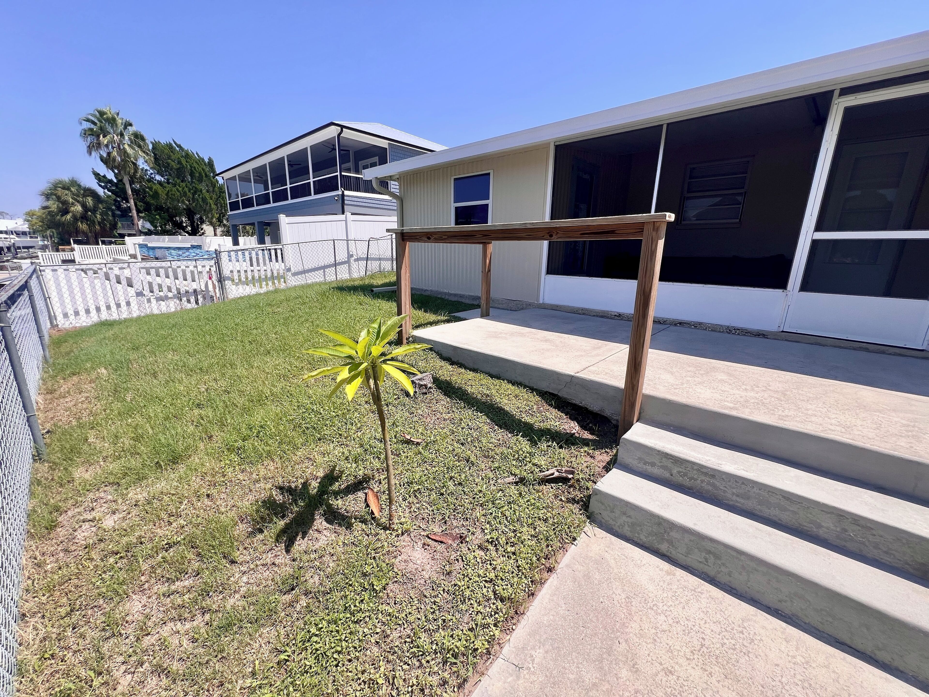 A residential area with a house, a small garden, and a metal fence.