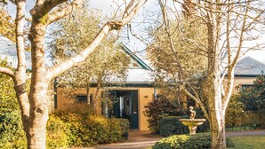 A building with a green roof, surrounded by trees and a well-maintained garden. - Blue Mountains Rhapsody - Point Blank Views Clifftop (Leura)