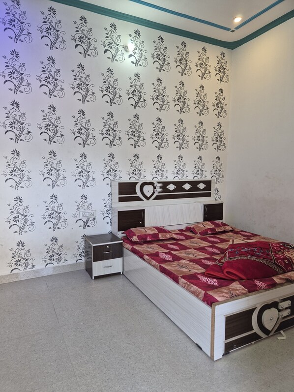 A bedroom with a bed, a nightstand, and a dresser.