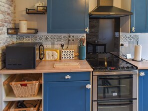 A kitchen with a stove, oven, and various kitchen items on the counter.