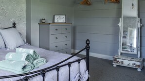 A bedroom with a bed, dresser, and dresser mirror. - 2 bedroom accommodation in Pakefield, near Lowestoft (Pakefield, near Lowestoft)