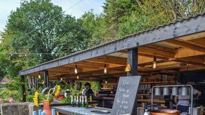 An outdoor bar with a wooden structure, bottles of wine, and a chalkboard menu. - 1 bedroom accommodation in Ruswarp, near Whitby (Ruswarp, near Whitby)