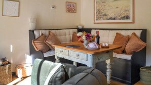 A cozy living room with a sofa, a wooden table, and a painting on the wall.