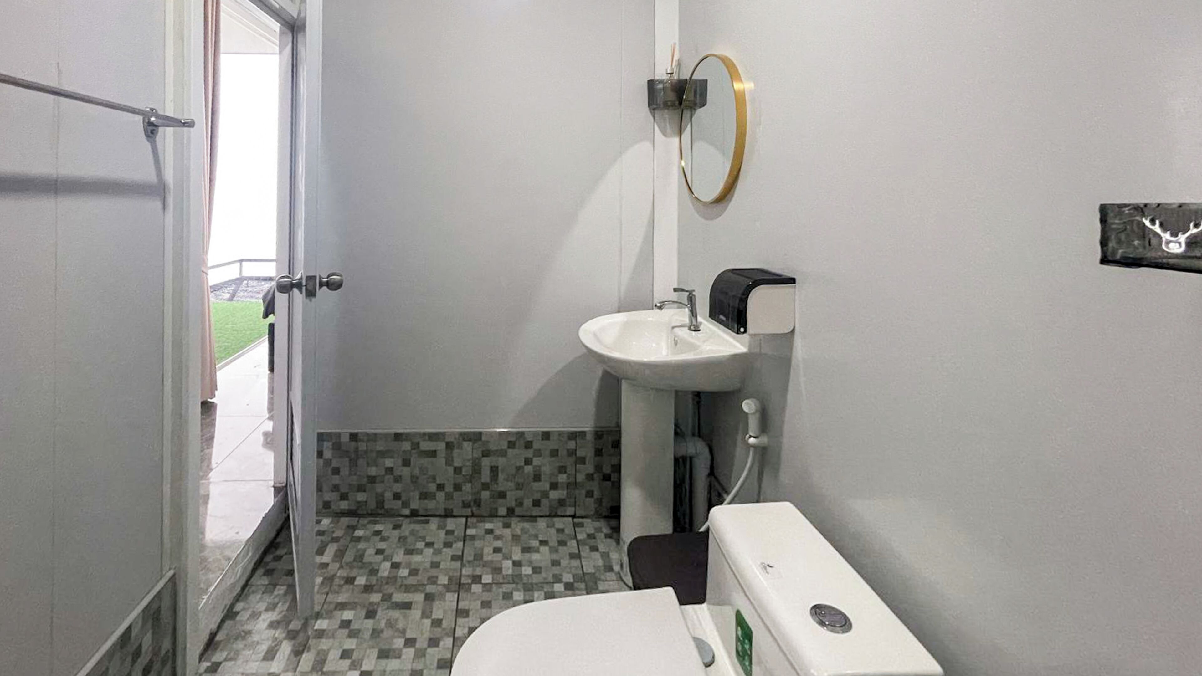 A small bathroom with a toilet, sink, and a mirror.