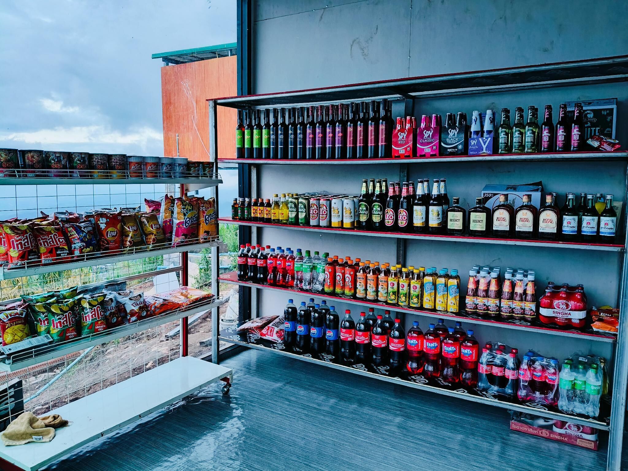 Een winkel met schappen vol verschillende drankjes en snacks.