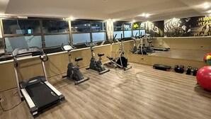 Une salle de sport équipée de tapis de course, de vélos d’appartement et de poids.