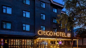 Un hôtel reconnaissable à son enseigne bien visible, à son entrée abritée et à sa façade en briques.