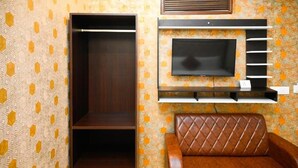A room with a wardrobe, a TV mounted on a wall, and a leather sofa. - HOTEL INFRAVIEW (Dera Bassi)