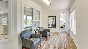 A hallway with two striped armchairs, a large mirror, and a wooden floor. - Yard & Dock: Waterfront Group Getaway in Biloxi (Biloxi)