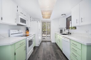 A modern kitchen with white cabinets, a built-in oven, and a dishwasher.