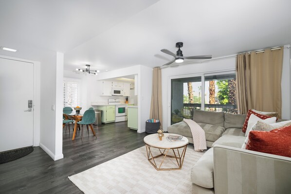 A modern living room with a sofa, coffee table, and dining area.