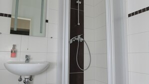 A modern bathroom with a glass-enclosed shower, a white sink, and a toilet. - BEWOS Gästehaus (Oschersleben)