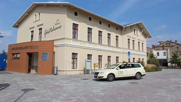 A building with a sign reading "ZOB OSCHERSLEBEN (BODE)" and a white car parked in front. - BEWOS Gästehaus (Oschersleben)
