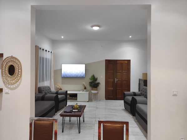 A modern living room with two sofas, a coffee table, a TV, and a wooden wardrobe.