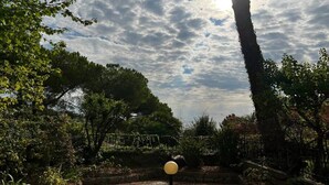 A garden with a variety of trees and plants, a stone pathway, and a spherical light post. - Garden view apartment in Sanremo with veranda (Sanremo)