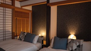 A hotel room with two beds, a traditional Japanese sliding door, and a textured wall. - ALLURE BEPPU (Beppu)