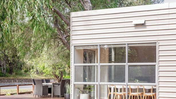A modern house with large windows, a deck, and outdoor furniture. - On The Bay: Sundrenched Stunner. Pet-friendly opposite beach. (Quindalup)