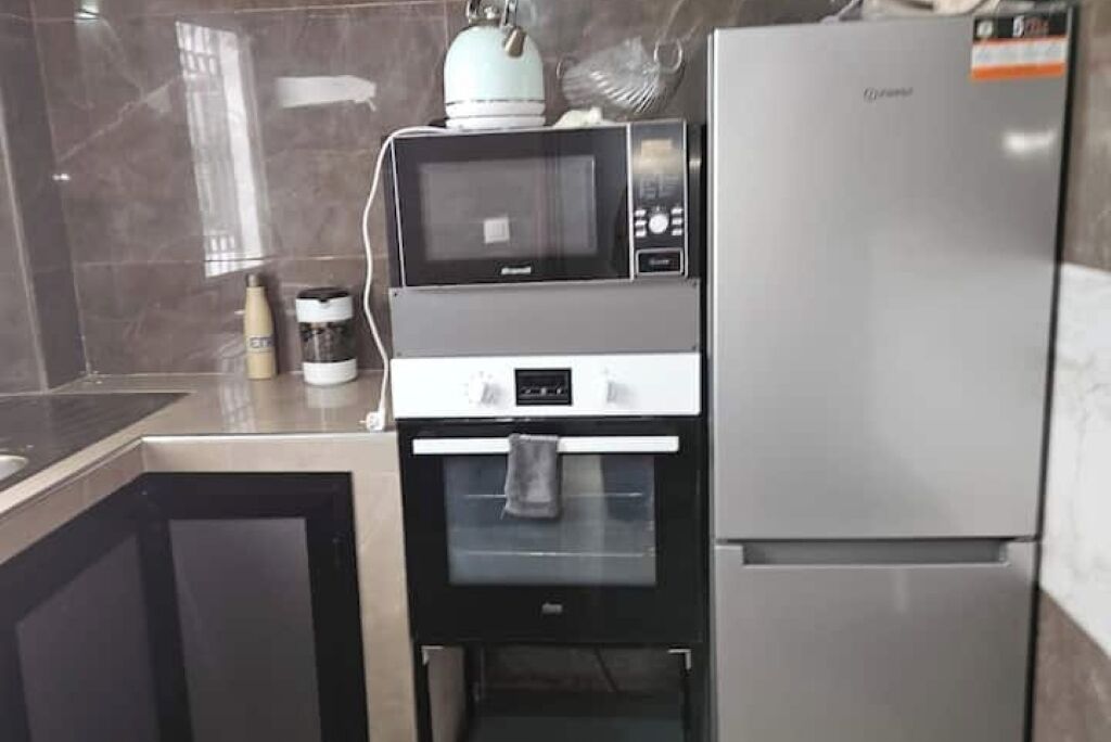 Une cuisine compacte équipée d’un four à micro-ondes, d’un four et d’un réfrigérateur.