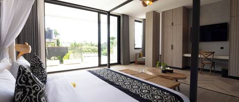 A modern hotel room with a large bed, a dining area, and a TV.