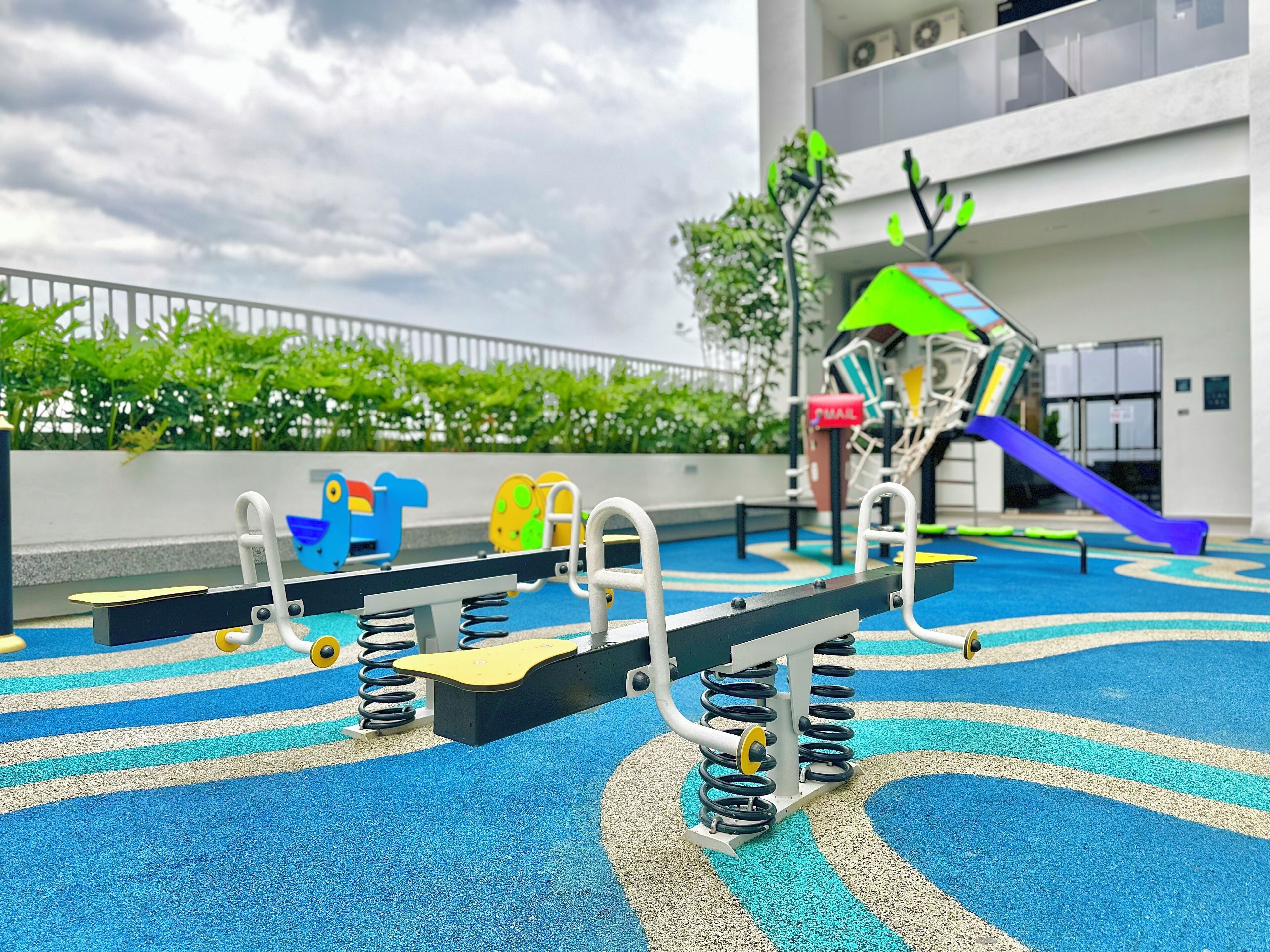 A playground with various equipment including swings, a seesaw, and a climbing structure.