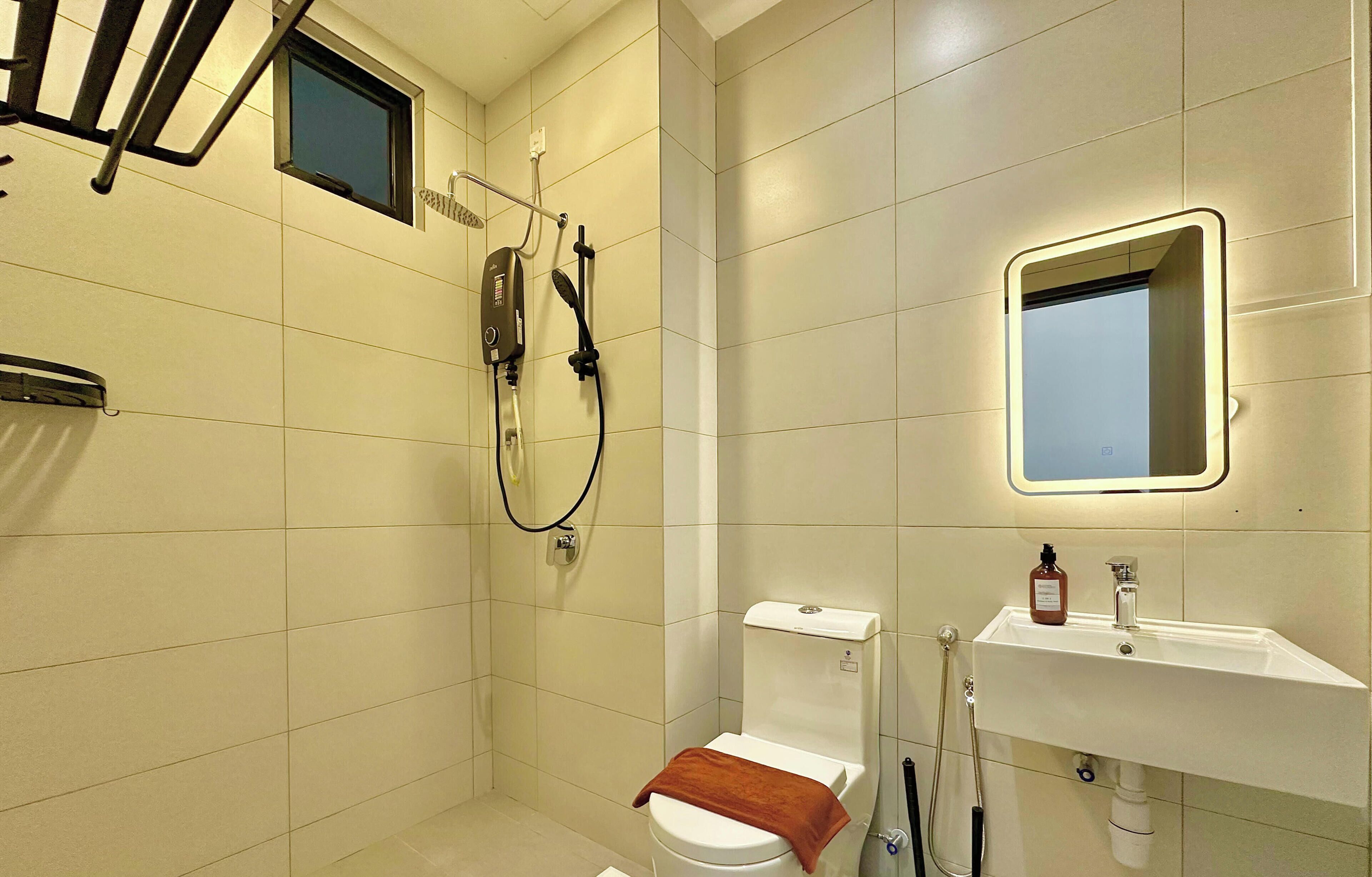 A modern bathroom with a toilet, shower, and sink.