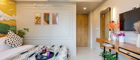 A modern bedroom with a bed, a bedside table, a mirror, and a wall-mounted air conditioner.