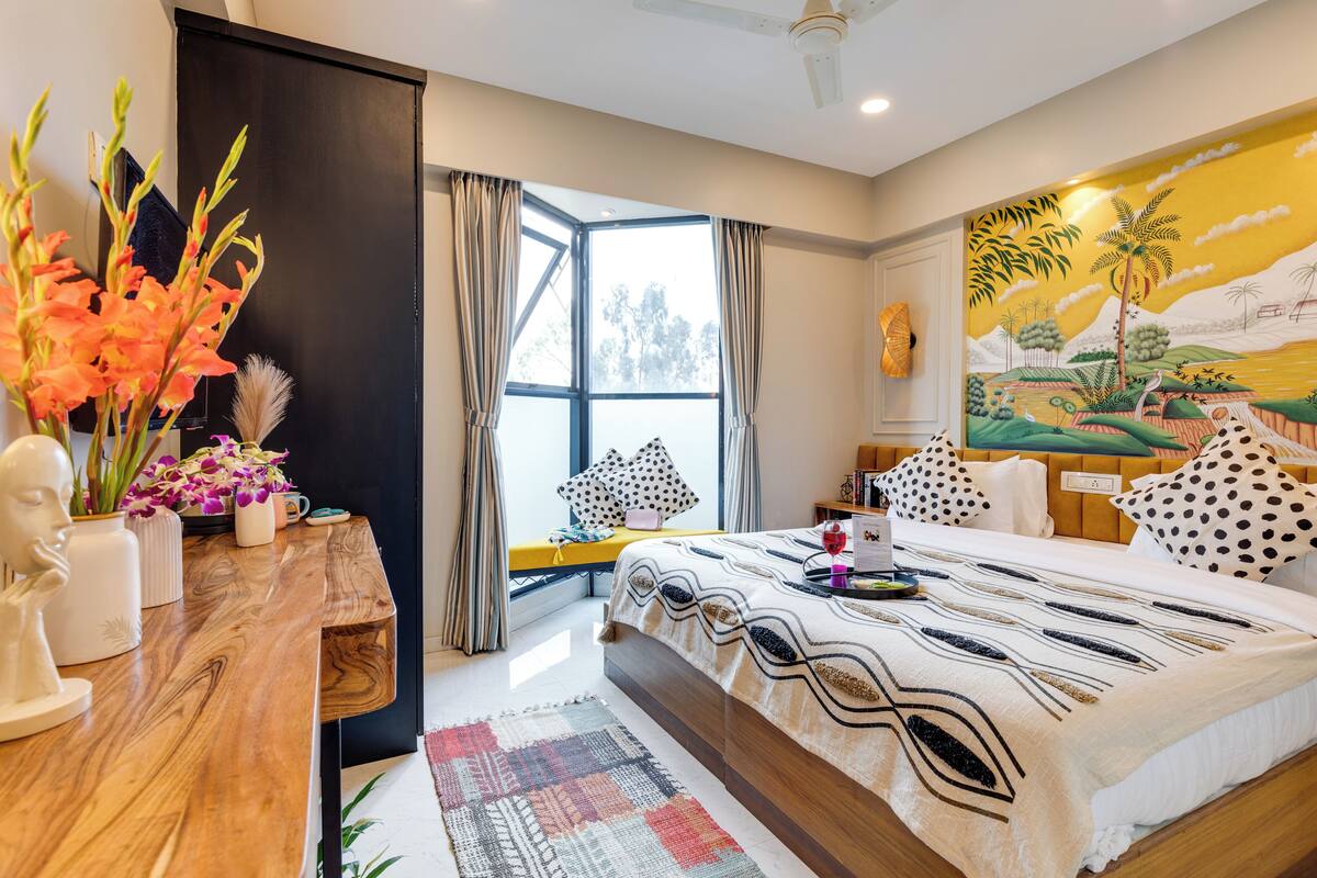 Une chambre moderne avec un grand lit, un bureau en bois et une fenêtre avec des rideaux.