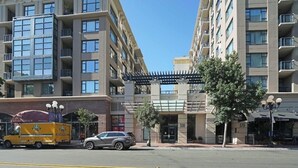 Un hotel de varios pisos con fachada moderna, balcones y un acceso cubierto.