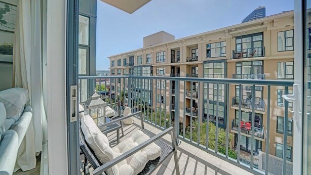 Un balcón con vistas a un edificio residencial de varios pisos.