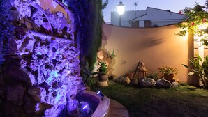 A garden with a rock wall, a small pond, and potted plants. - 'Ideal Vacation Sun & Beach' Apartment with Private Pool, Terrace & Wi-Fi (Marbella)