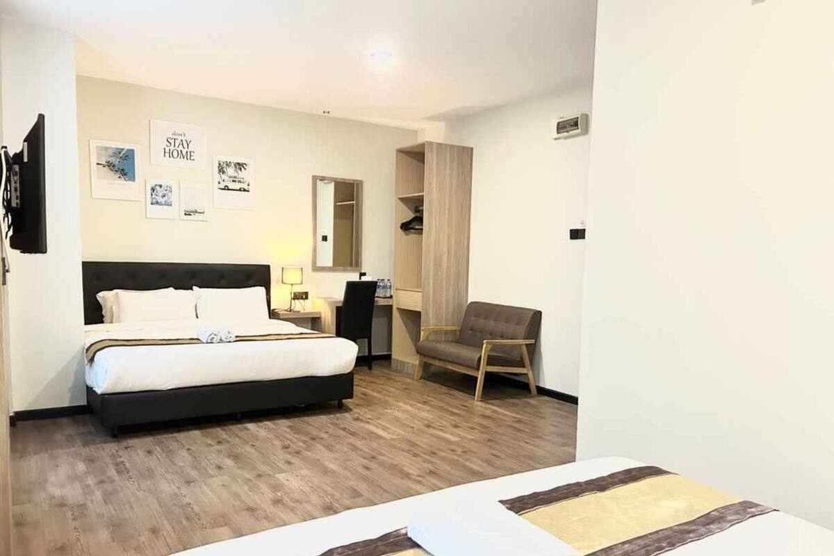Une chambre d’hôtel avec un lit, un bureau, une chaise et une armoire.