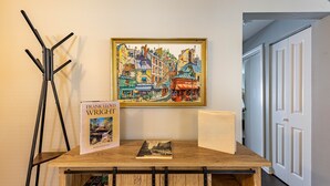 Una mesa de madera con libros y un cuadro enmarco.