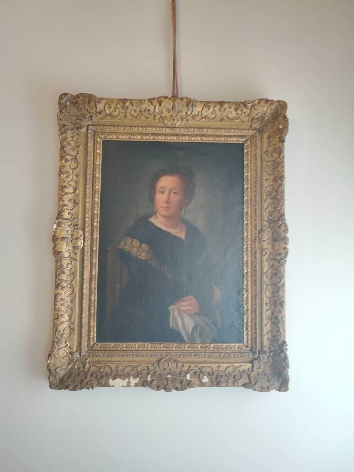 A portrait framed in an ornate gold frame.